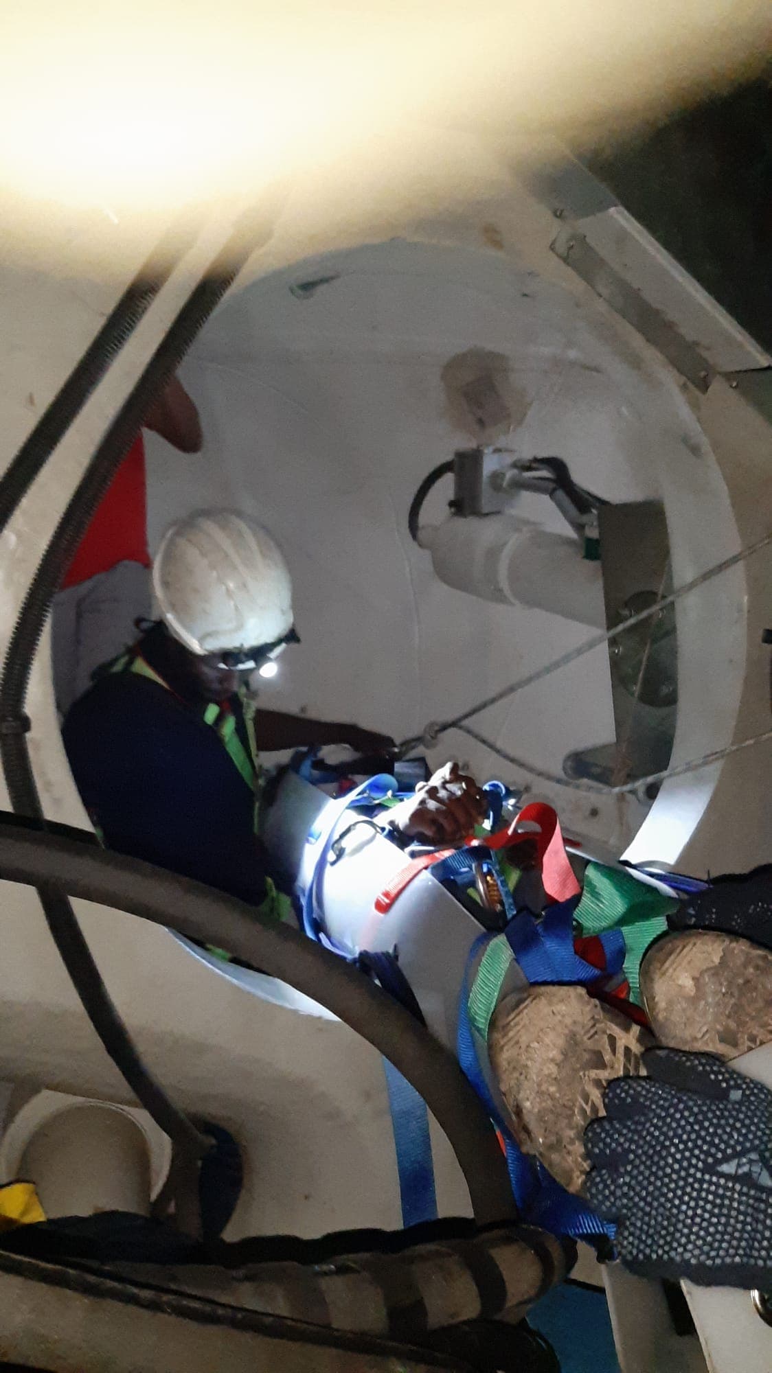 Casualty in a rescue stretcher being moved through a circular blade root opening during rescue training