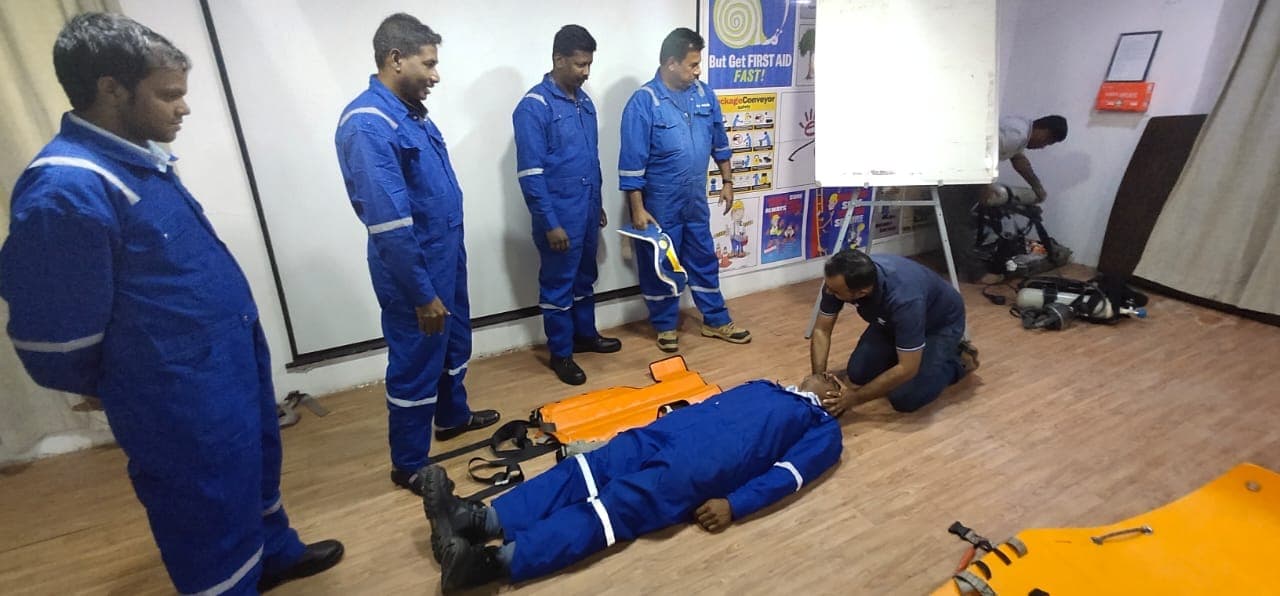 Participants gathered around rescue equipment laid out on the floor before a drill