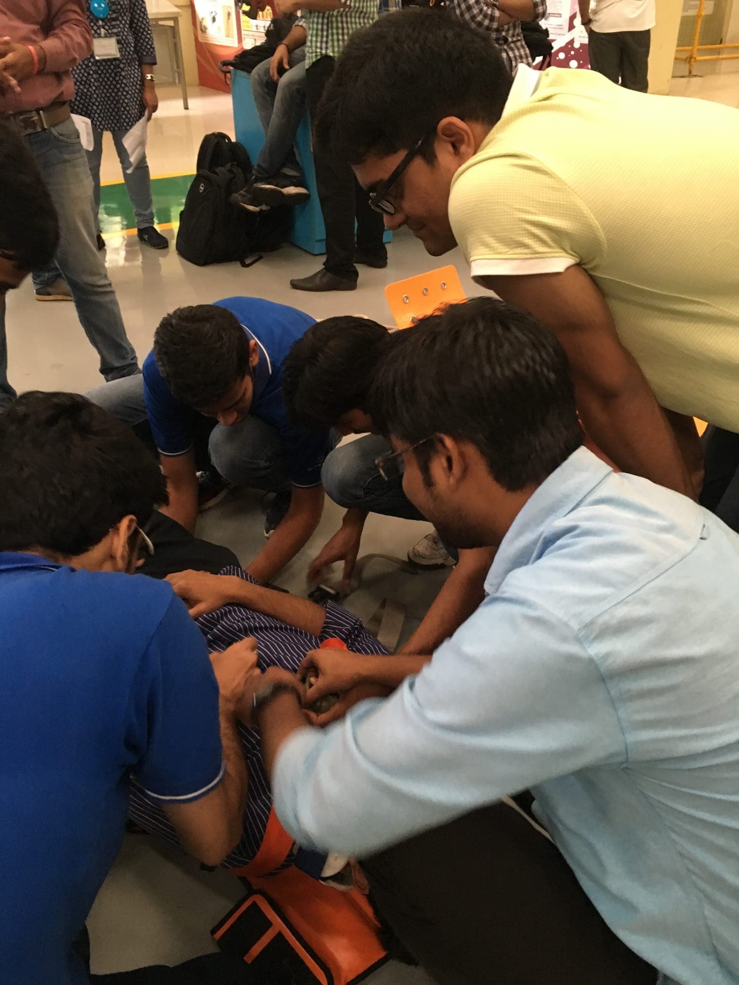 Participants securing a casualty onto a stretcher with straps during practical rescue training