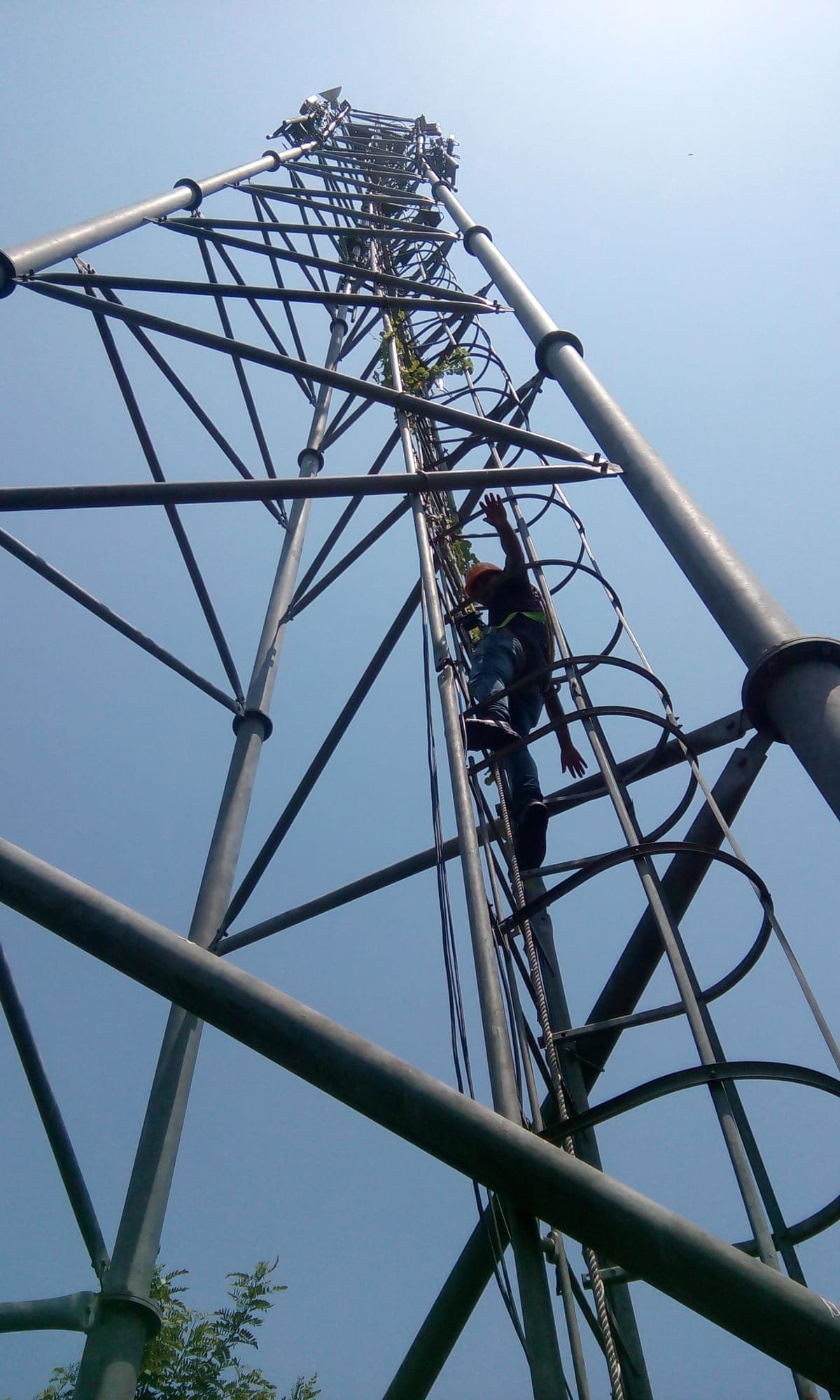 Participant climbing a lattice steel tower during a work at height practical