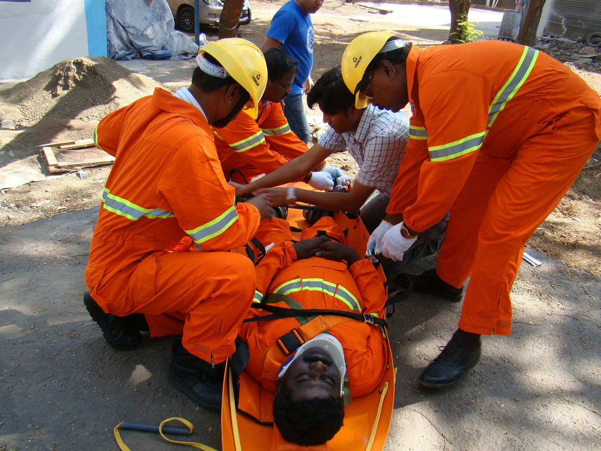 Rescue team securing a casualty to a stretcher during a confined space rescue exercise