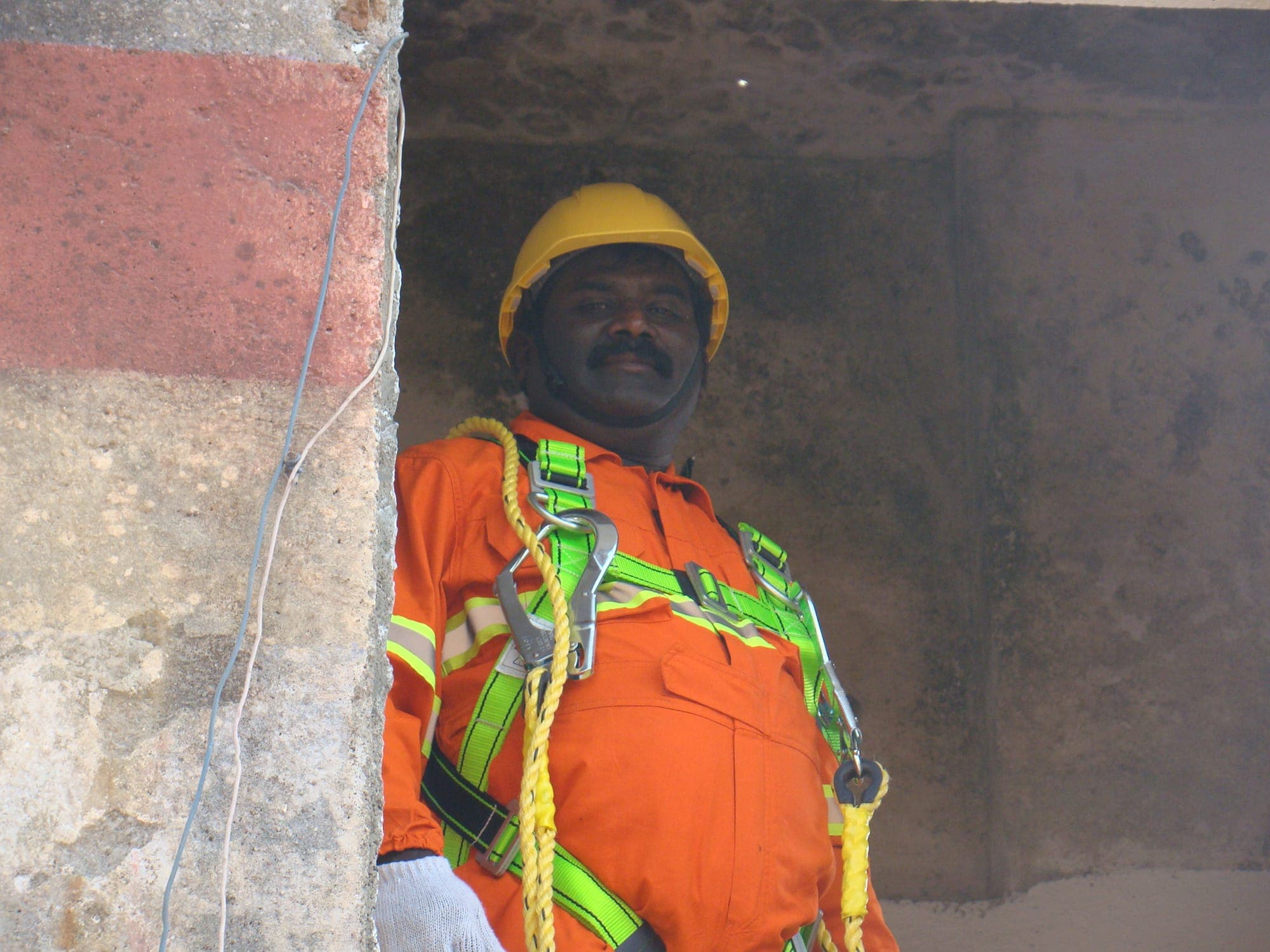 Trainee wearing a full body harness at a confined space entry point, prepared for entry