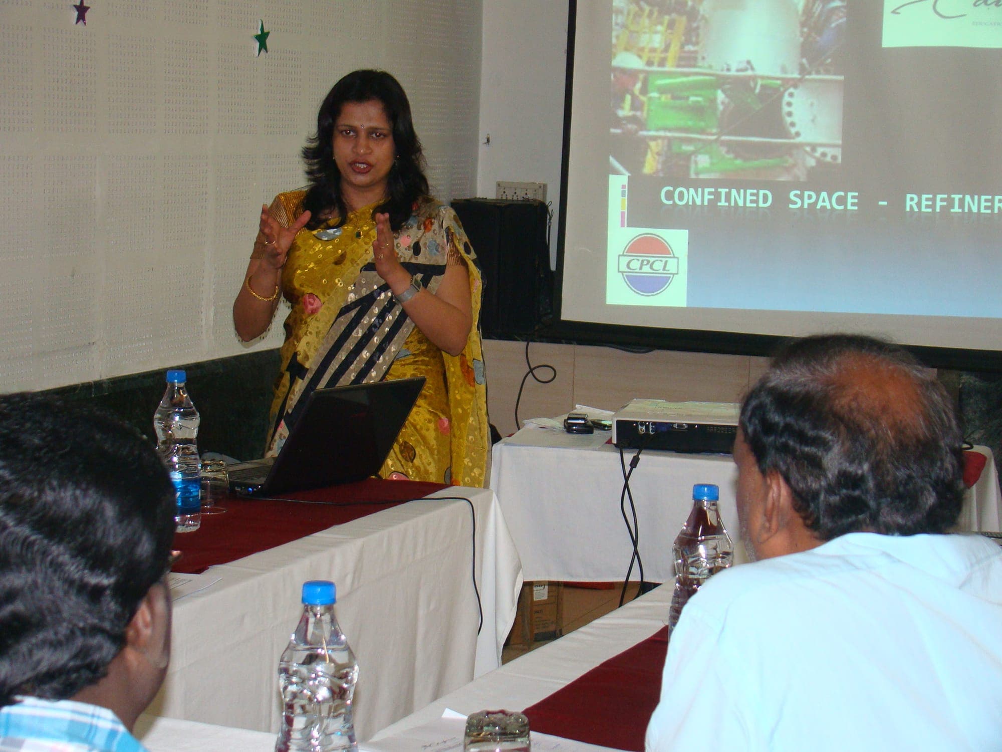 Trainer presenting a confined space training session to seated participants, with course slides projected on screen