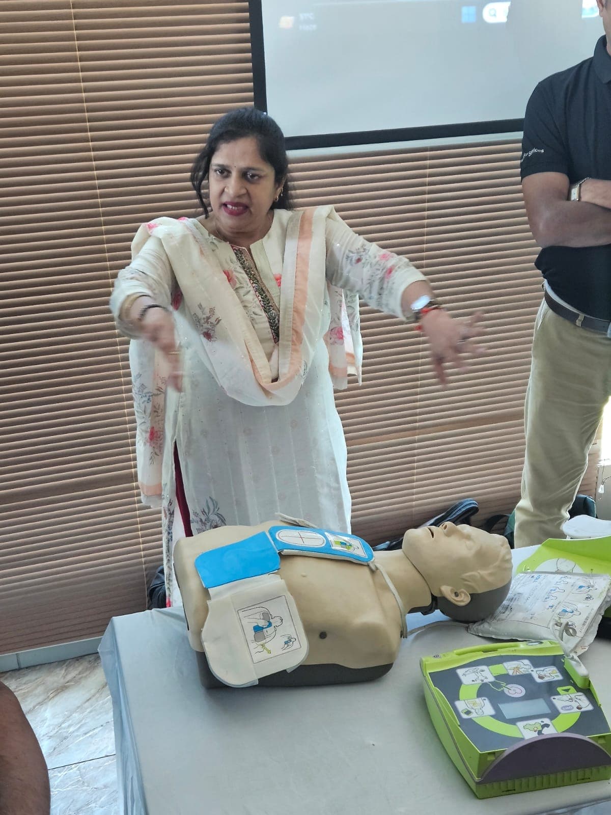Trainer demonstrating an automated external defibrillator with a CPR manikin
