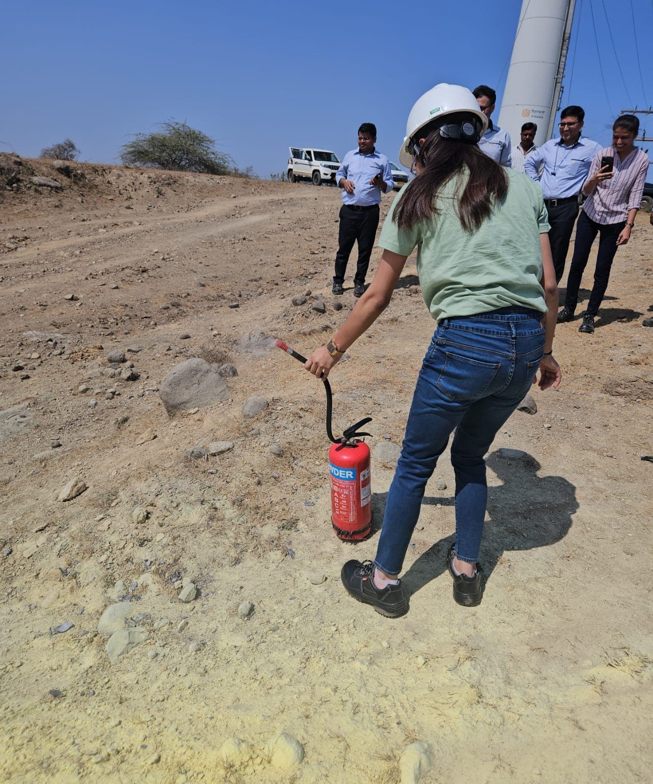Participant carrying a fire extinguisher towards a fire point during hands-on training