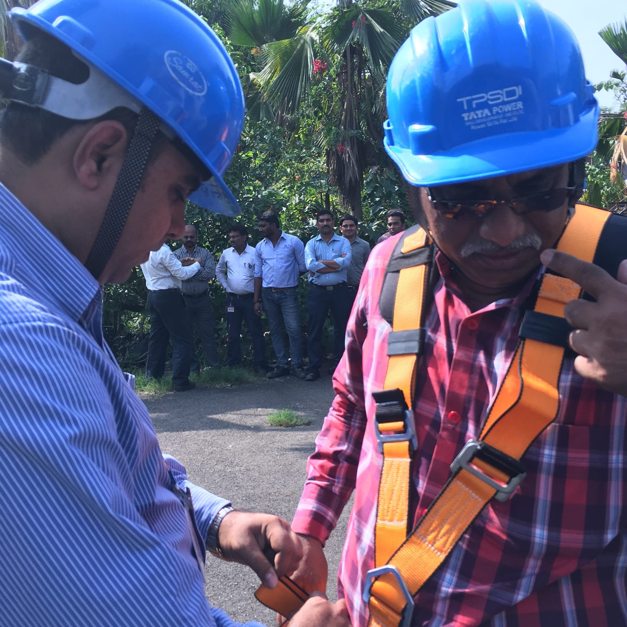 Instructor checking the adjustment of a trainee's full-body harness before a work at height exercise