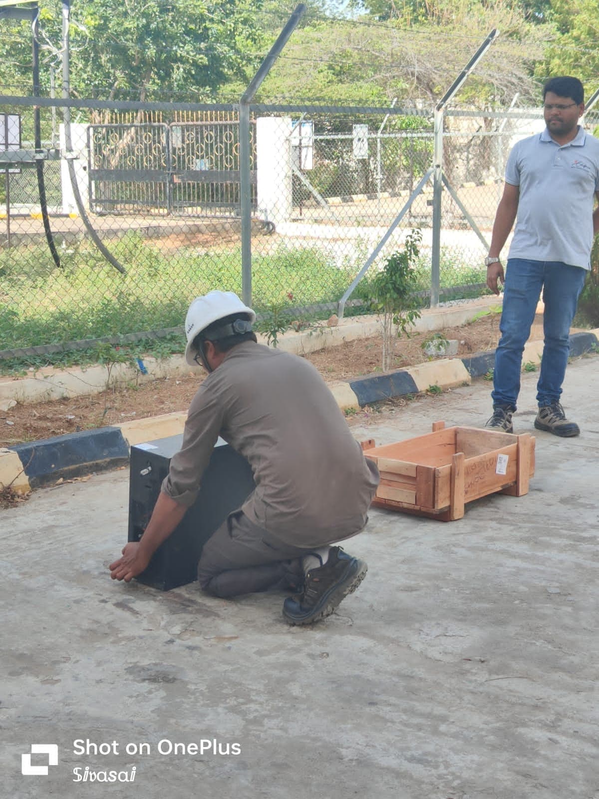 Participant demonstrating correct manual lifting technique with a box on open ground