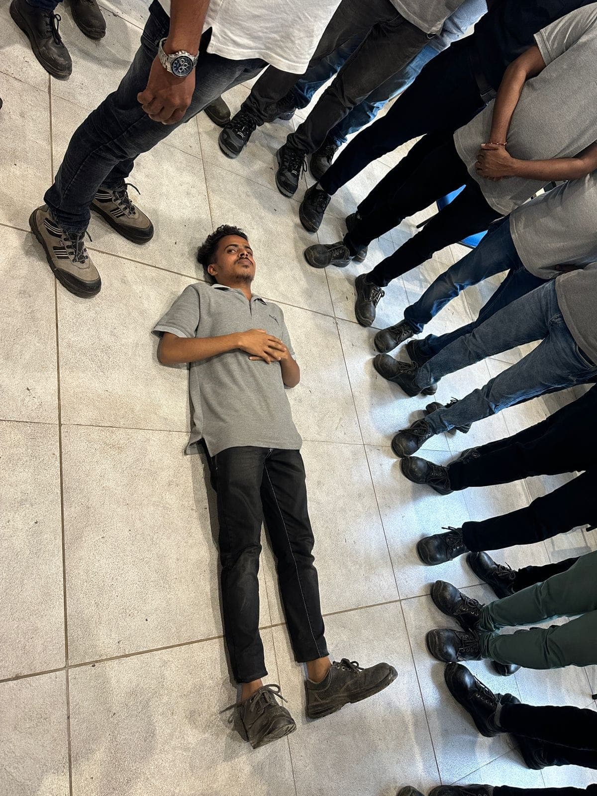 Participant placing a volunteer casualty in the recovery position during first aid training