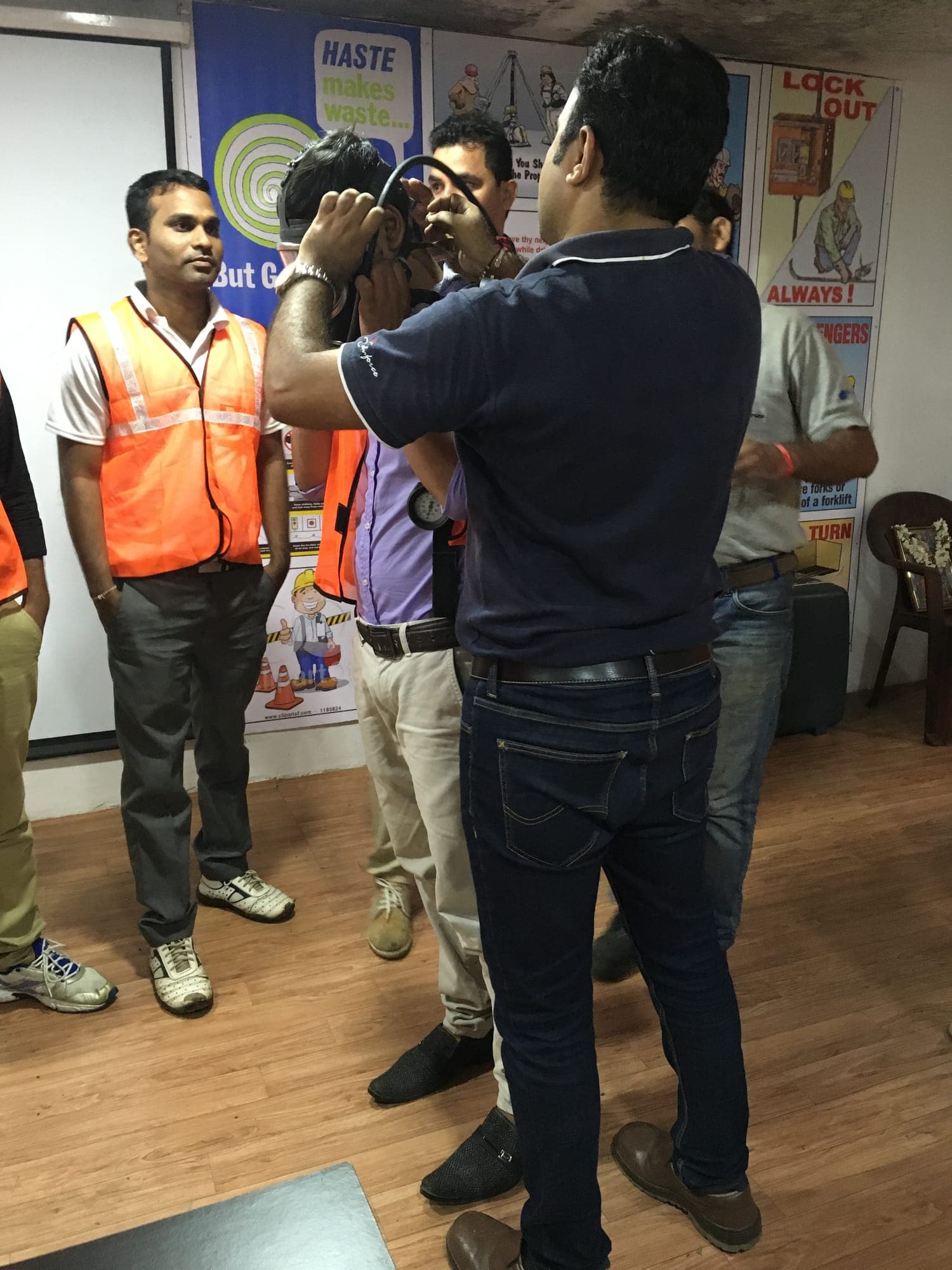 Participant being helped to fit the face mask of a self-contained breathing apparatus set