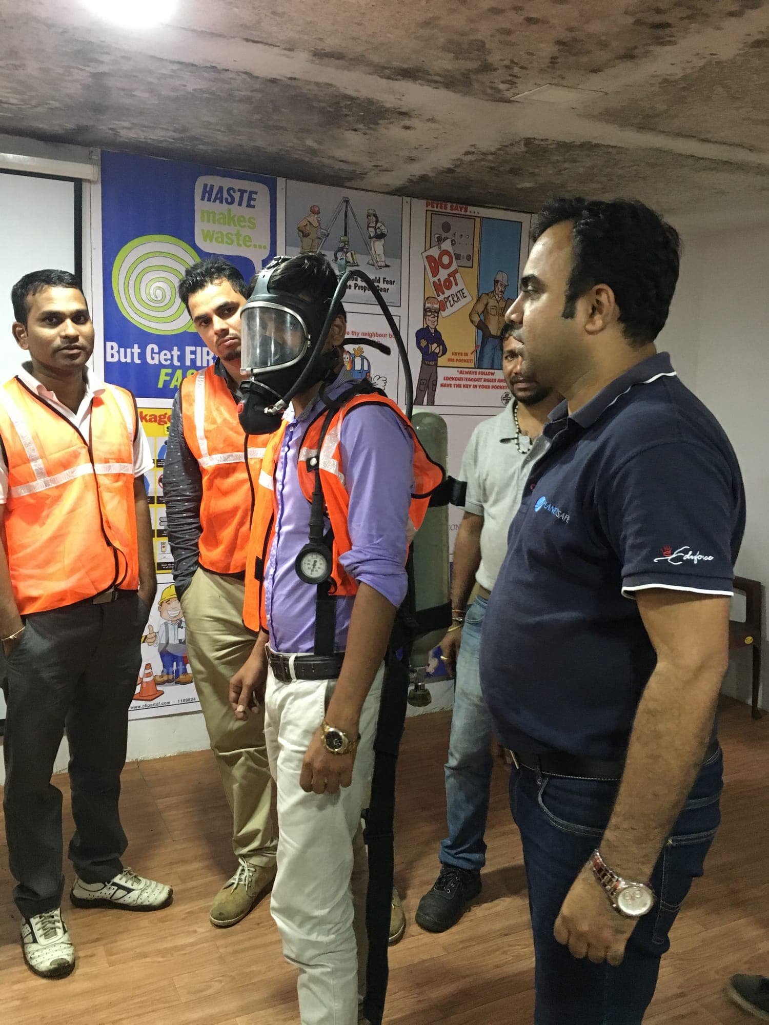 Instructor briefing participants in high visibility vests on the use of self-contained breathing apparatus