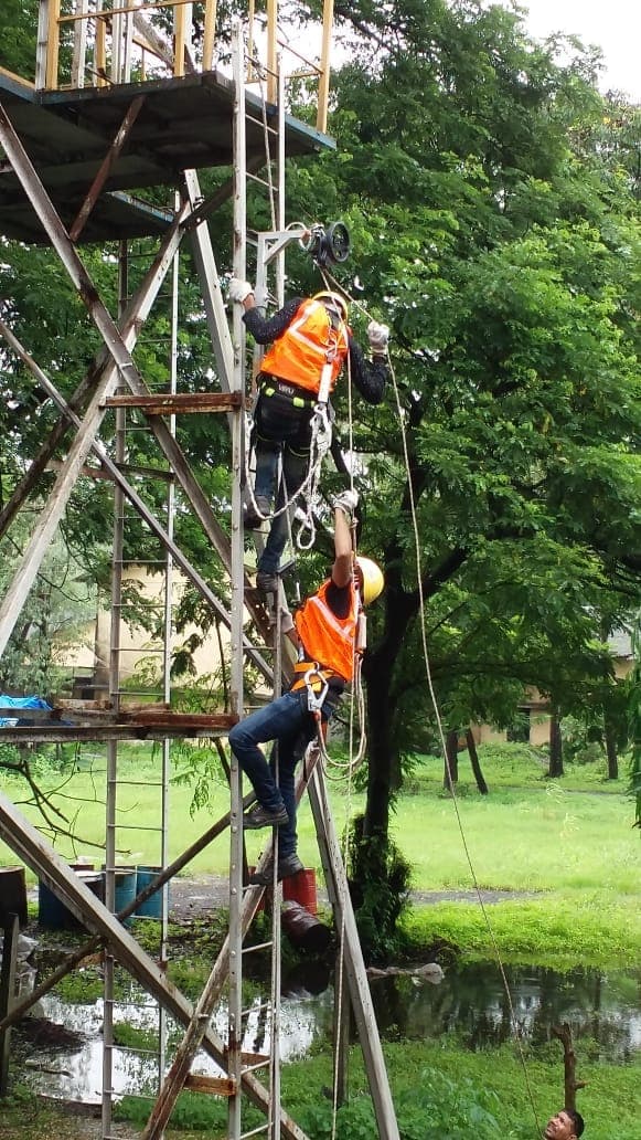 Trainee working at height on an outdoor steel training structure while attached to an anchor point