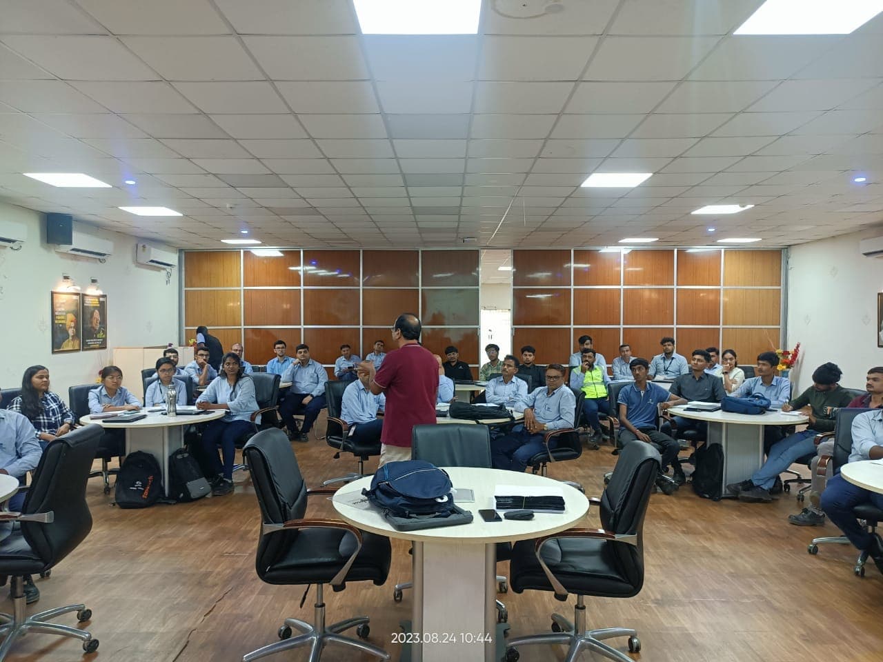 Trainer presenting a rigging and lifting session to participants seated at round tables
