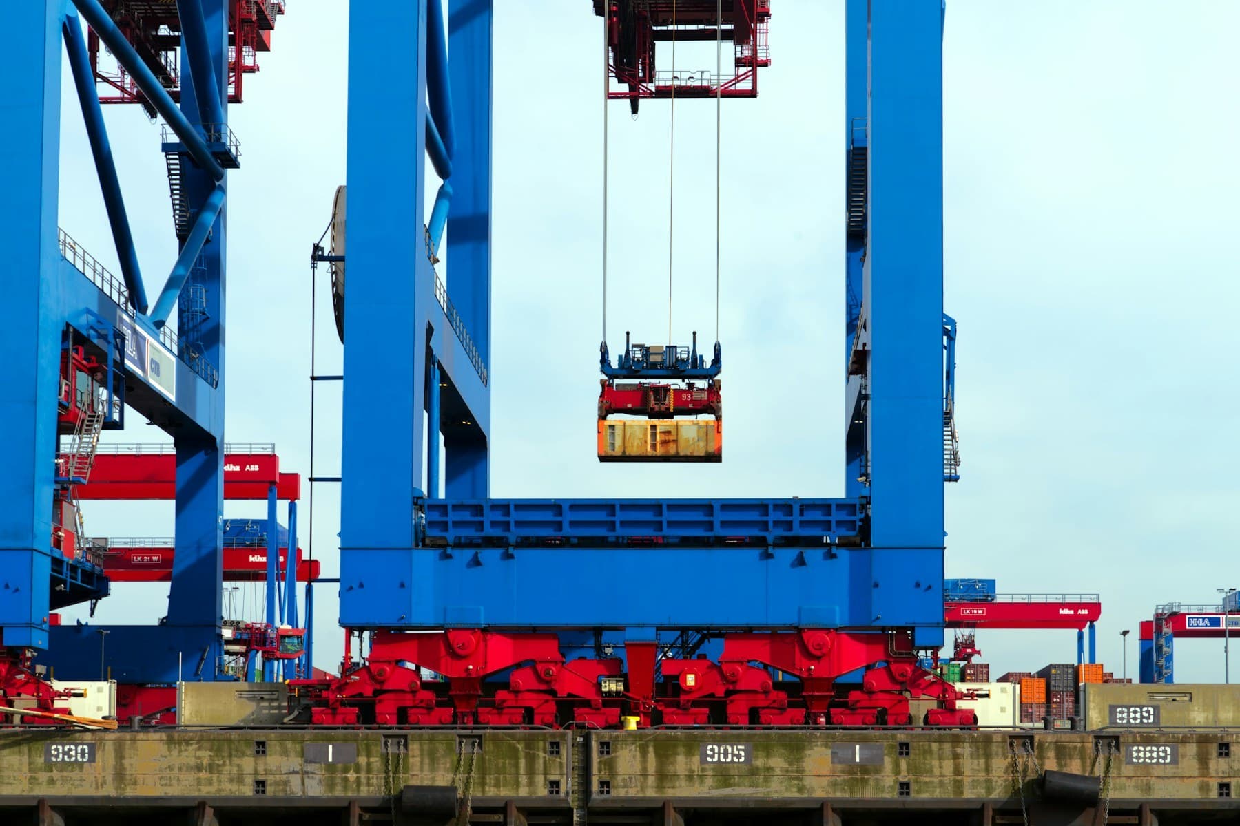 Container gantry crane lifting a container over a port terminal quay